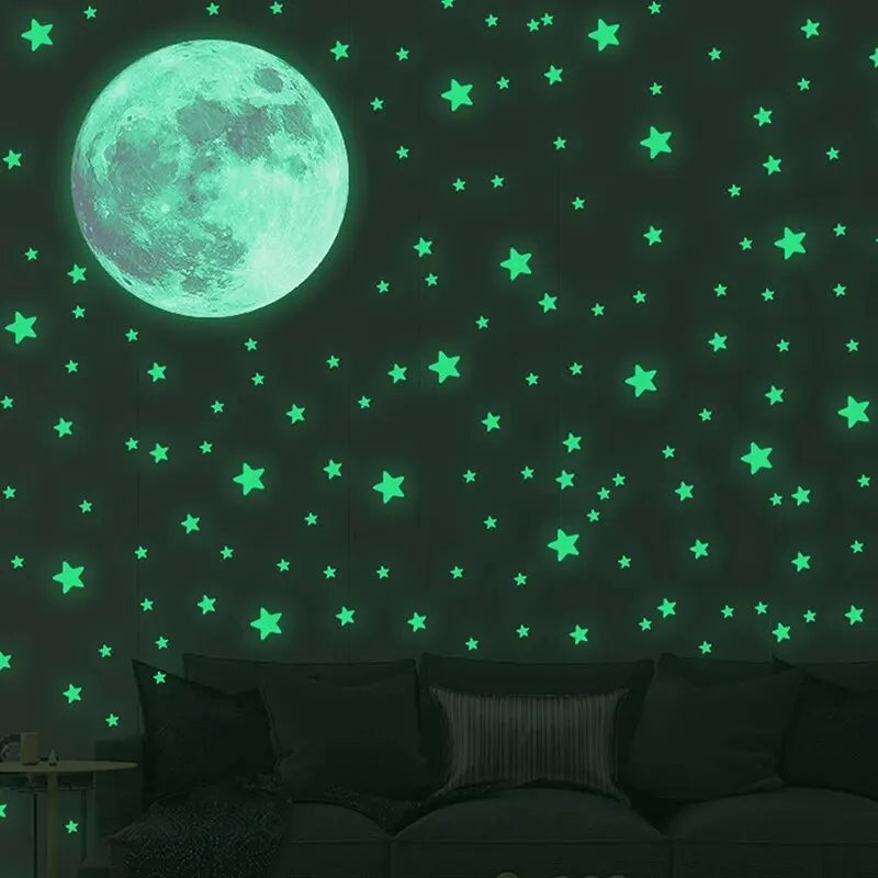 Green glow in the dark moon and stars above the silhouette of a sofa in a dark room