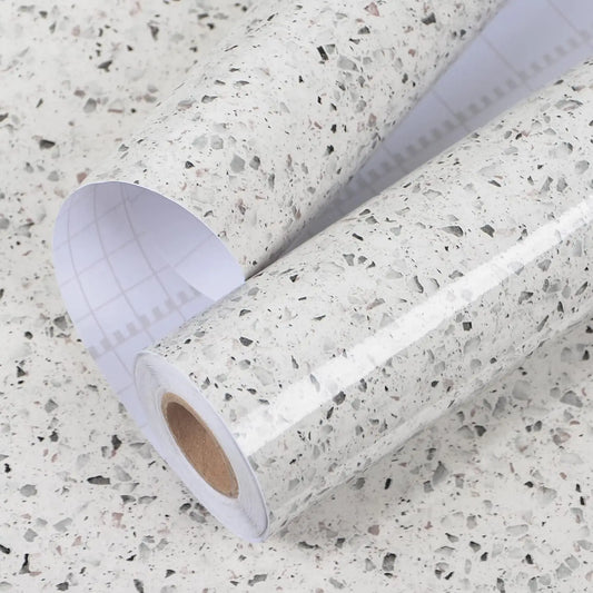 Rolle weiße Möbelfolie in Terrazzooptik mit angehobenem Schutzpapier mit Raster