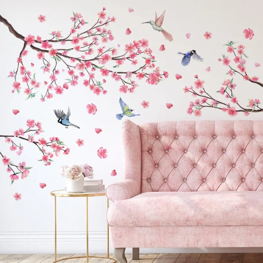 Kersenbloesemtakken met vogels op een muur achter een roze bank