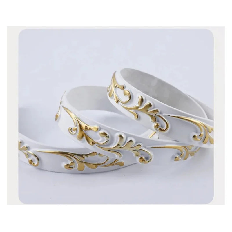 Two rings of white decorative moulding with gold floral relief