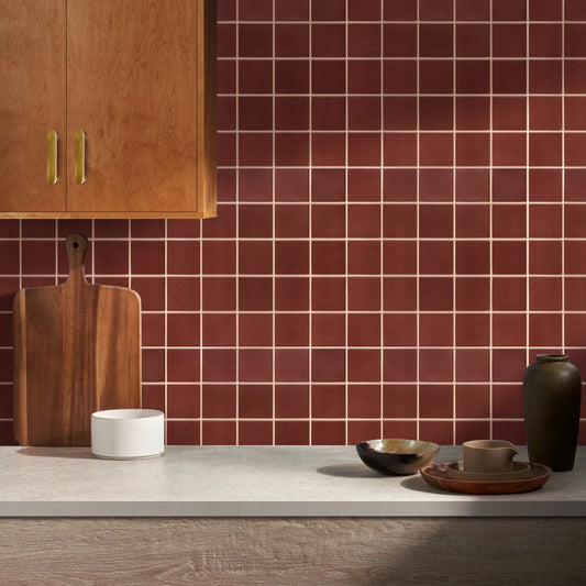 Küchenspritzschutz mit roten selbstklebenden quadratischen Paneelen, neben einem Holzschrank