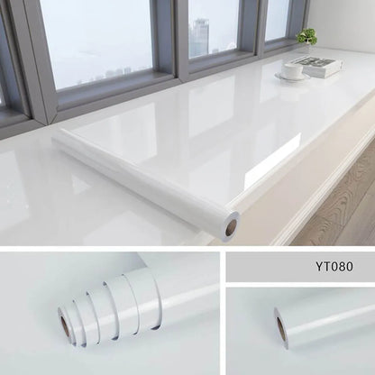 Rolle weiße Klebefolie in Marmoroptik auf einer hellen Fensterbank, mit zwei Detailaufnahmen der Rolle