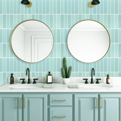 Bathroom with two round mirrors and a light blue wall of rectangular tiles above the washbasin
