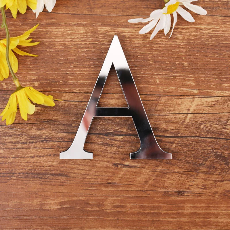 Letter A in silver mirror acrylic, 20 cm, on a wooden table with flowers
