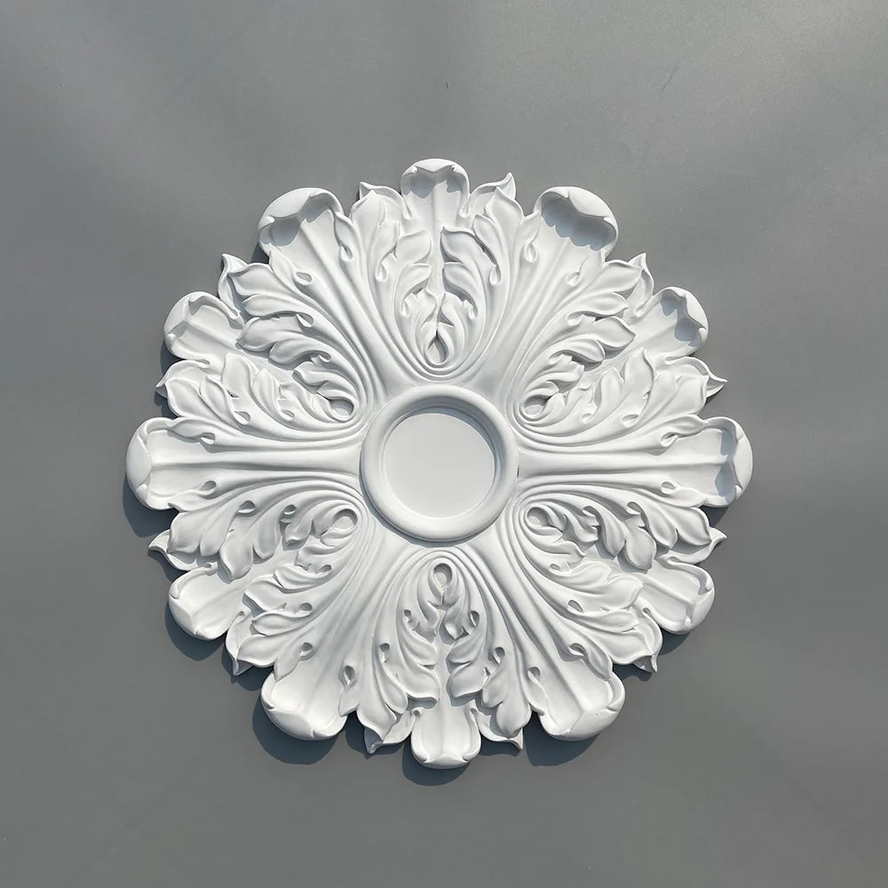 Decorative white polyurethane ceiling rose with leaf relief, seen from above, on a grey background