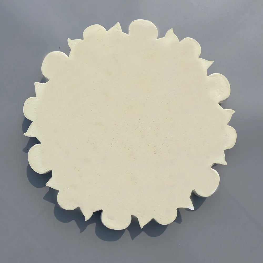 Back of the ceiling rose: solid cream disc with a lobed edge