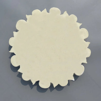 Back of the ceiling rose: solid cream disc with a lobed edge
