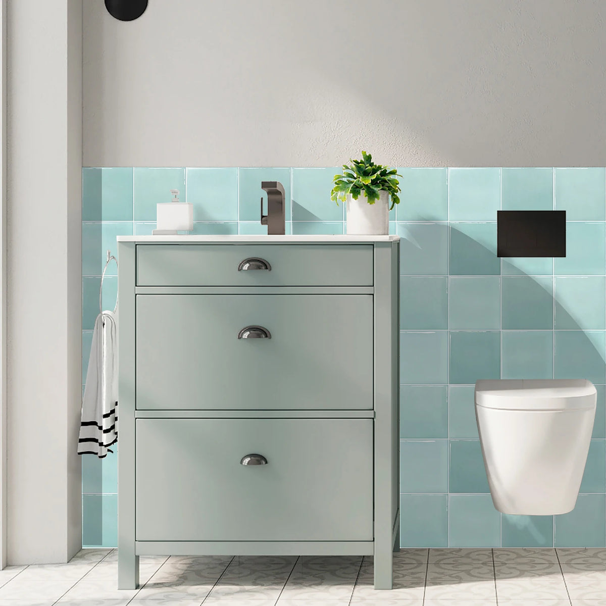 Bathroom with grey unit and toilet in front of a wall of turquoise tile stickers