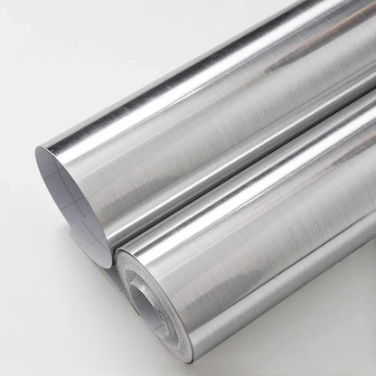 Two rolls of silver brushed stainless steel effect adhesive vinyl on a light background