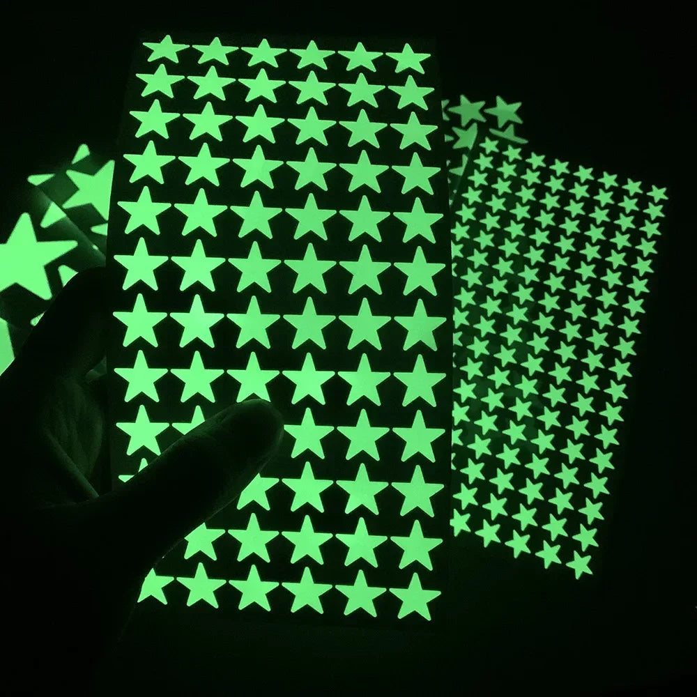 Glow in the dark adhesive star sheets for peeling, with a blurred hand below