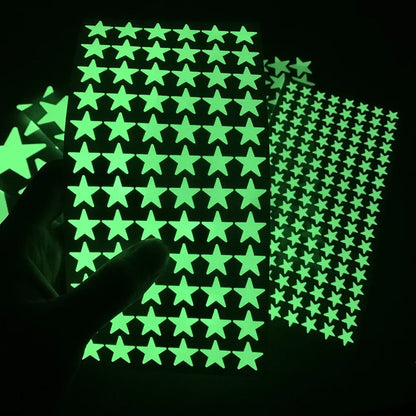 Glow in the dark adhesive star sheets for peeling, with a blurred hand below