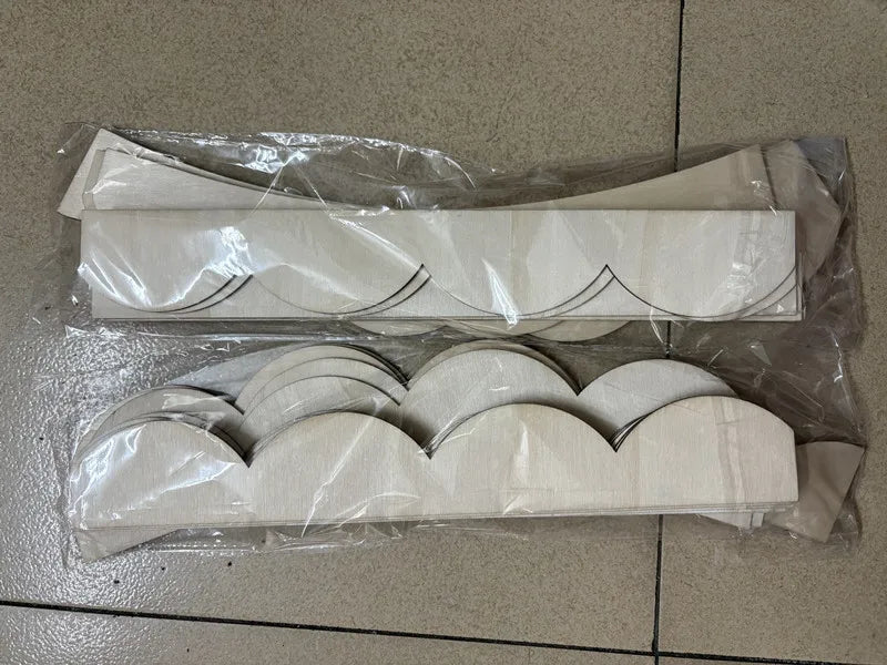 Twee zakjes met de lichte houten stukken van de decoratieve boog