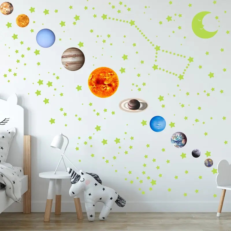 White wall with planets, moon and stars stuck on a diagonal beside a soft toy