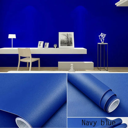 Wand in intensivem Blau mit weißem Schreibtisch und Details der Rolle blauer selbstklebender Tapete