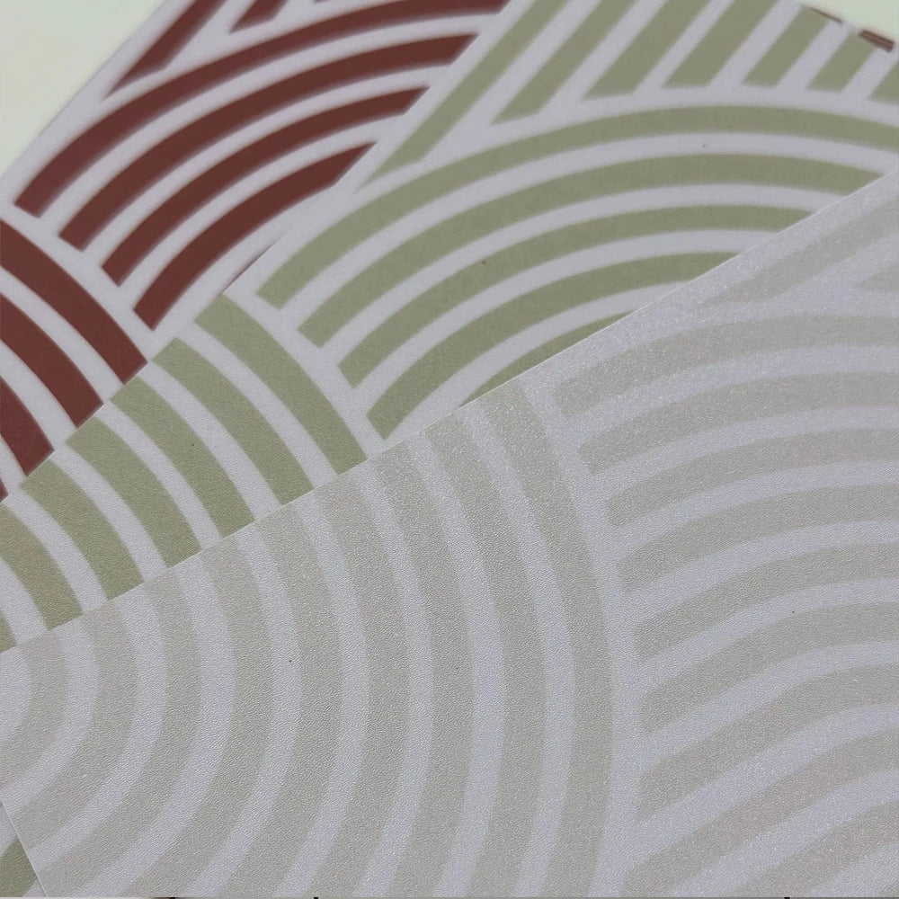 Three tile stickers with arches in terracotta, olive green and cream, overlapping, in close-up