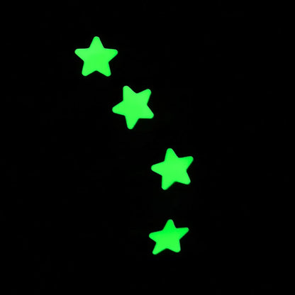 Four glow in the dark stars on a black background
