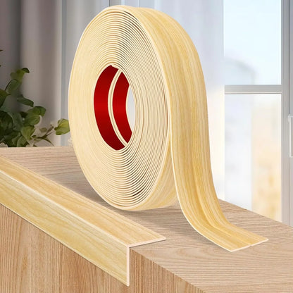 Rolle selbstklebender Zierleiste in heller Holzoptik auf einer Holzecke