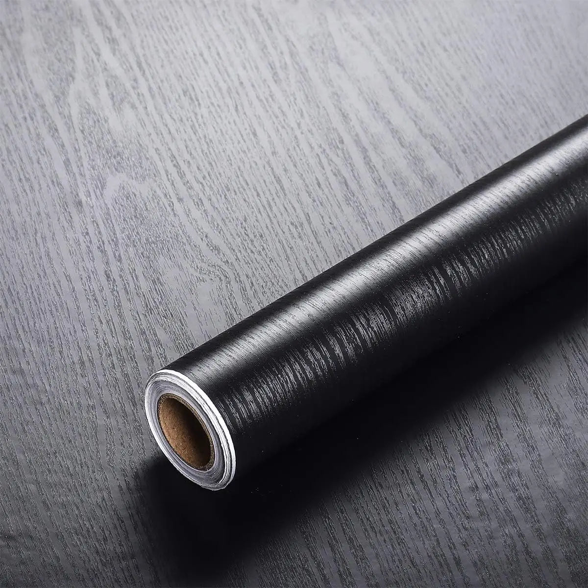 Roll of black wood effect vinyl wrap, Model 2, on a dark wood background