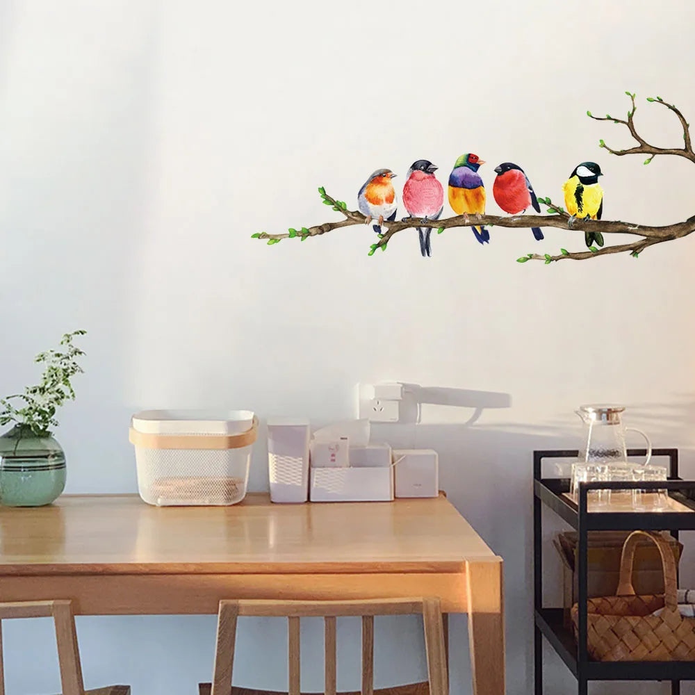Muursticker met vogels op een tak, geplaatst op een houten keukentafel