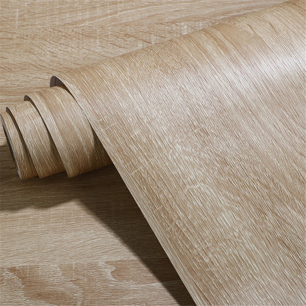 Close-up of a roll of light grey beige wood effect vinyl with embossed grain