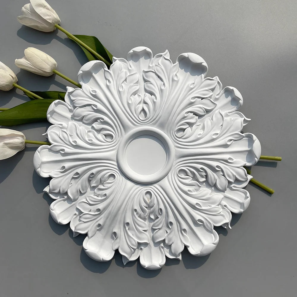 White leaf ceiling rose beside white tulips on a grey background