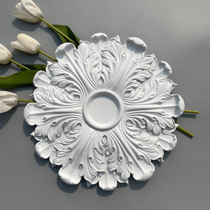 White leaf ceiling rose beside white tulips on a grey background