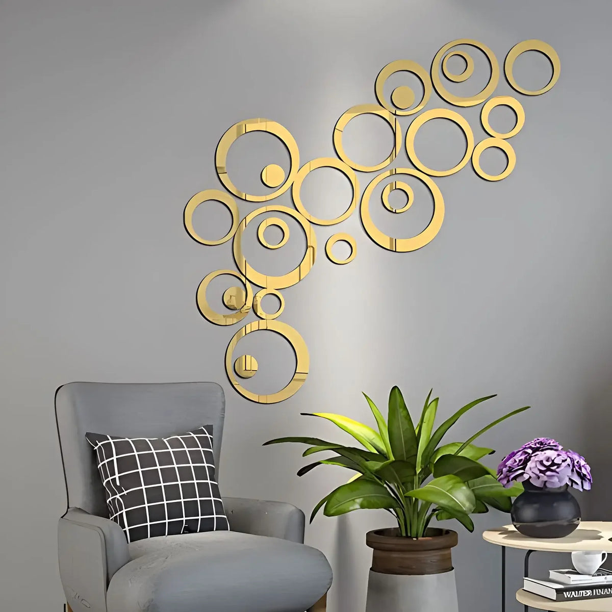 Gouden spiegelcirkels op een grijze muur naast een fauteuil