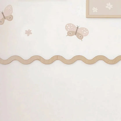 Holzleiste in Wellenform auf halber Wandhöhe in einem weißen Kinderzimmer, mit zwei verbundenen Stücken