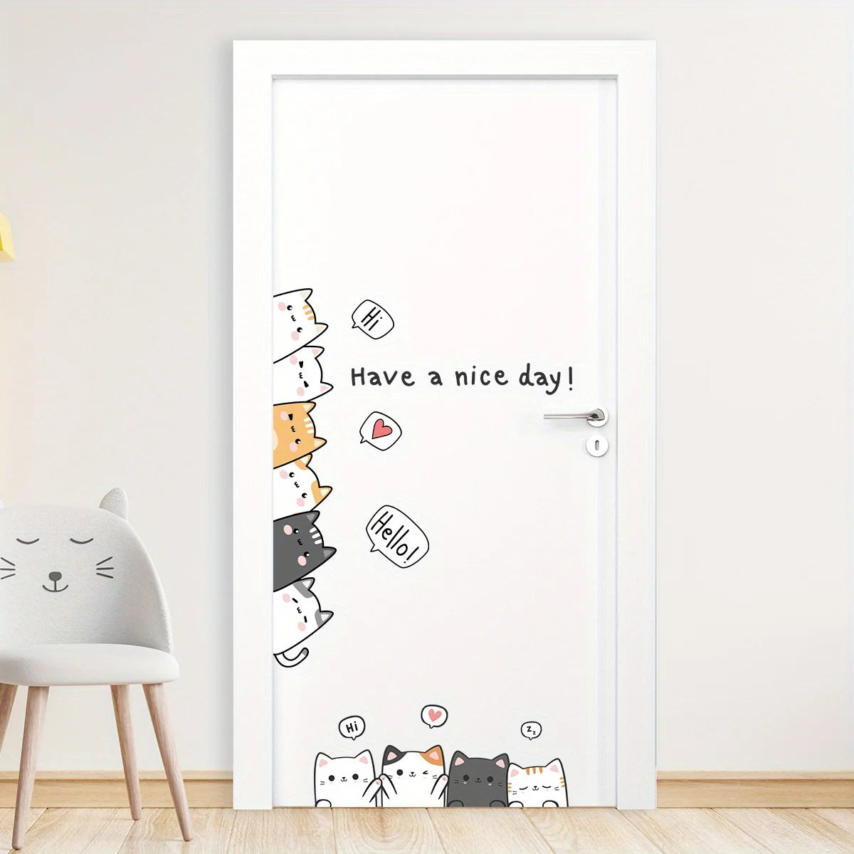 White door with cartoon cat stickers, next to a nursery chair