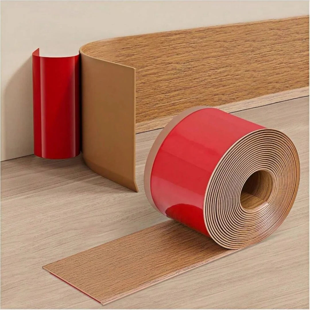 Rolle selbstklebende Sockelleiste in gelber Eichenoptik mit roter Folie, Streifen über Holzboden abgerollt