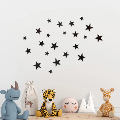 Black adhesive stars on a white wall beside soft toys