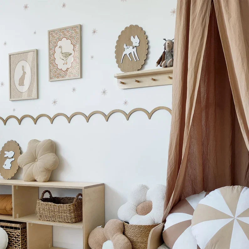 Kinderkamer met een sierlijst met schulprand van licht multiplex op een witte muur, boven een lage boekenkast