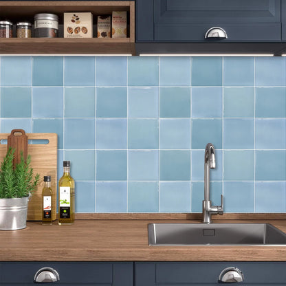 Kitchen with sink and wooden worktop in front of light blue gradient tile stickers