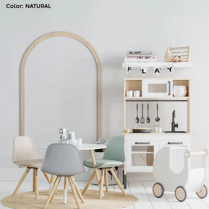 Lichte multiplex boog op een lichtgrijze muur in een kinderkamer met een speelgoedkeuken en stoelen