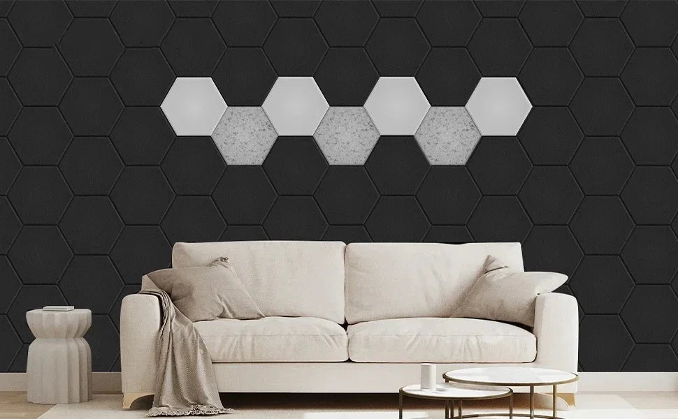 Living room wall with black acoustic hexagons and a row of light hexagons behind a sofa