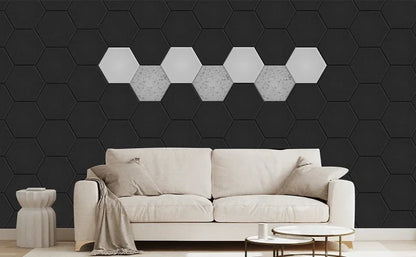 Living room wall with black acoustic hexagons and a row of light hexagons behind a sofa