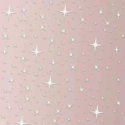 Close-up of sparkling silver stars on a pink wall