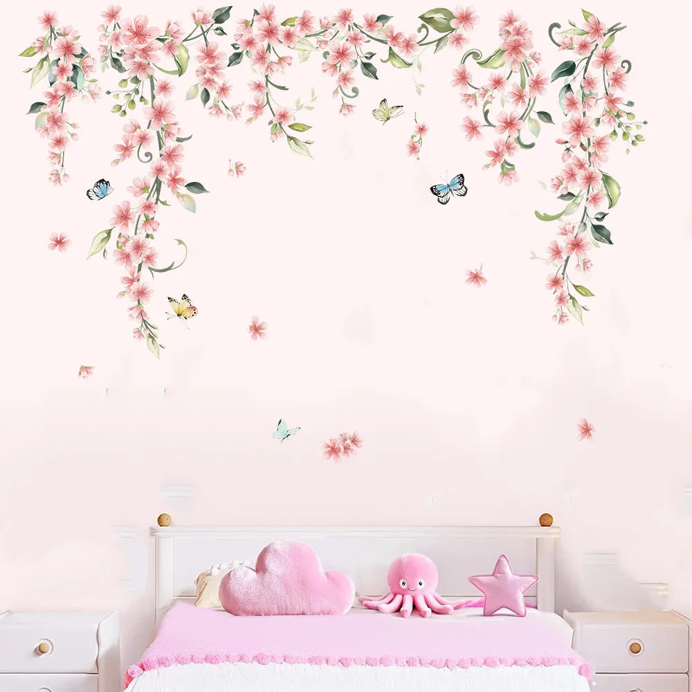 Roze klimbloemen-muursticker op een roze muur boven een kinderbed met kussens