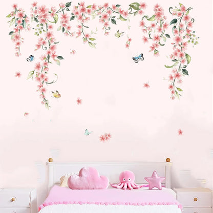 Roze klimbloemen-muursticker op een roze muur boven een kinderbed met kussens