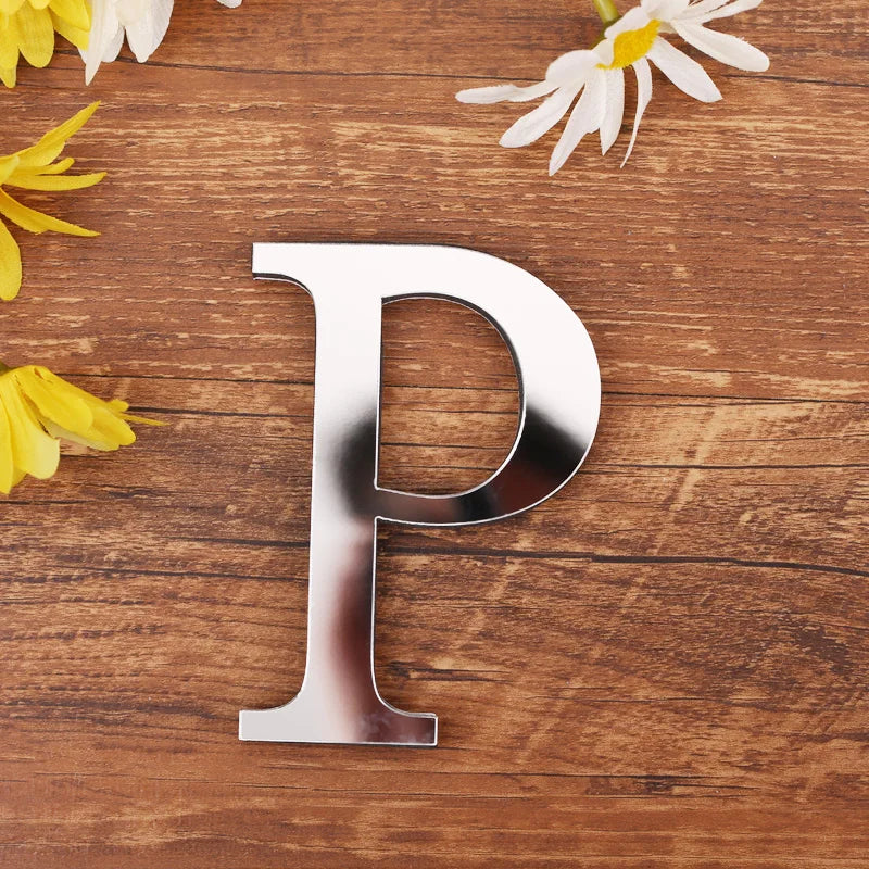 Letter P in silver mirror acrylic, 20 cm, on a wooden table with flowers