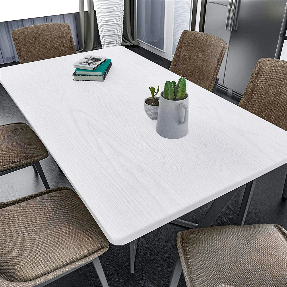 White table with chairs, a book and a plant, covered in white wood effect vinyl wrap
