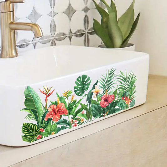 Monstera, palmbladeren en rode hibiscus in vinyl op de witte voorkant van een wastafel