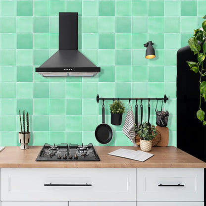 Kitchen with black cooker hood and a wall of mint green tile stickers