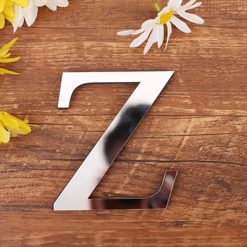 Letter Z in silver mirror acrylic, 20 cm, on a wooden table with flowers
