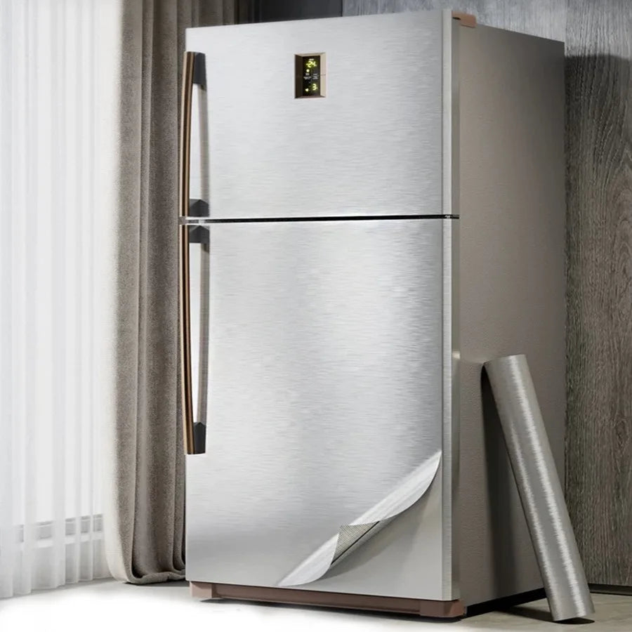 Fridge with freezer covered in silver vinyl, with one corner lifted and a roll beside it