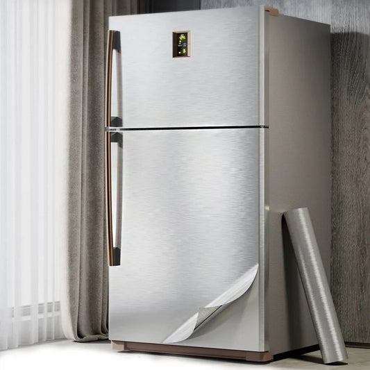 Fridge with freezer covered in silver vinyl, with one corner lifted and a roll beside it