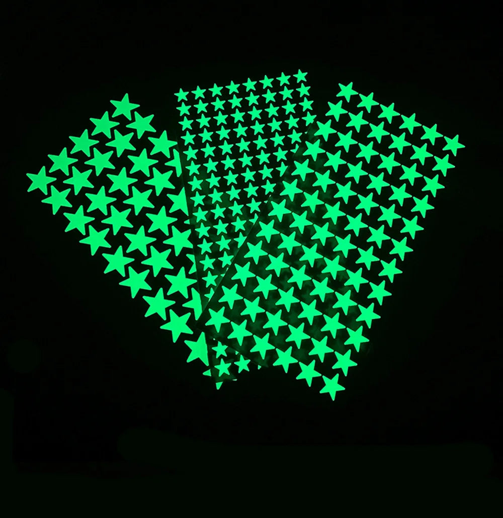 Three glow in the dark star sheets overlapping in a fan shape on a black background