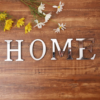 Word HOME spelled with silver mirror letters on a wooden table