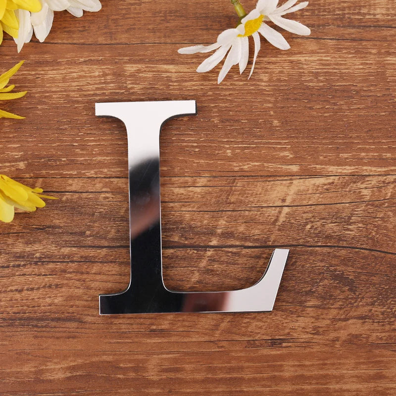 Letter L in silver mirror acrylic, 20 cm, on a wooden table with flowers