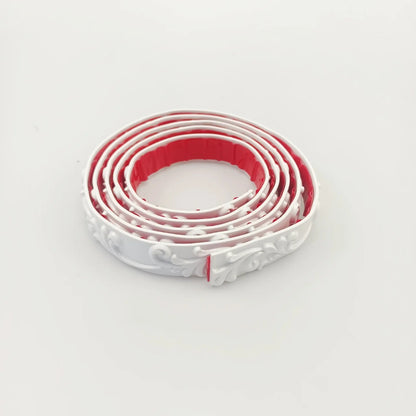 White decorative moulding rolled up, seen from above with the red adhesive back